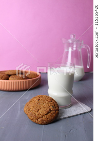 oatmeal multigrain biscuits, a glass of milk on a pink background with space for text. Healthy baby food afternoon snack concept 115365420