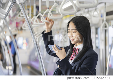 高中女孩在火車上看智慧型手機 115365687