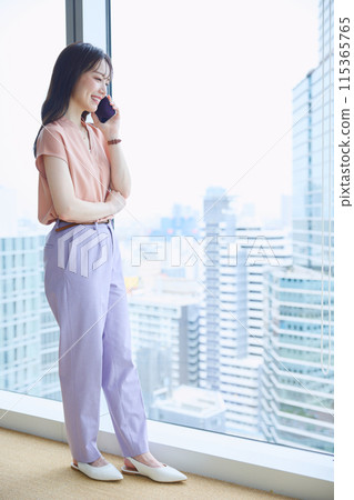 辦公室窗邊打電話的女人 115365765