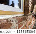 Window installation. The process of insulating windows with construction foam. A builder's hand seals the cracks between the building and the window frame. Construction and insulation of the building. 115365804