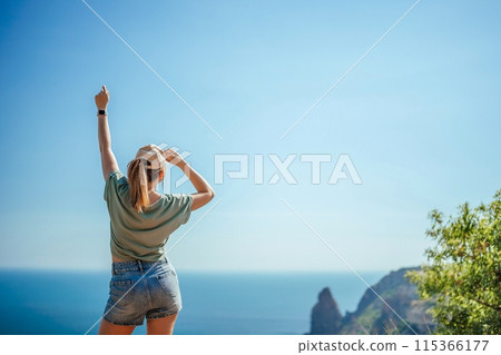 Woman tourist sky sea. Happy traveler woman in hat enjoys vacation raised her hands up 115366177