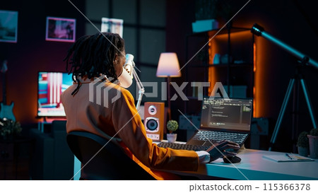 University student and coding enthusiast delves into cloud computing, expanding her knowledge beyond online class lessons. African american girl using programming language. Camera B. 115366378