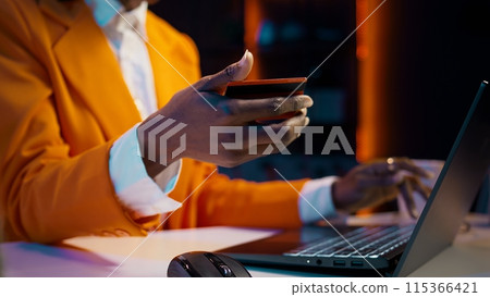 African american girl doing online shopping session at home, typing debit card numbers to finish website order. Young woman purchasing clothes with easy pay e banking, home delivery. Camera B. African american girl doing online shopping session at home, typing debit card numbers to finish website order. Young woman purchasing clothes with easy pay e banking, home delivery. Camera B. 115366421