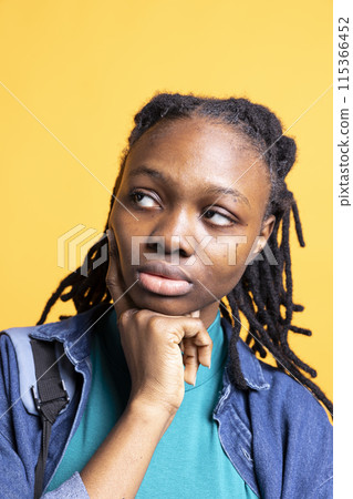 African american woman thinking, being lost in thoughts, isolated over studio background, close up shot. Pensive BIPOC young girl contemplating, caught in imagination process African american woman thinking, being lost in thoughts, isolated over studio background, close up shot. Pensive BIPOC young girl contemplating, caught in imagination process 115366452