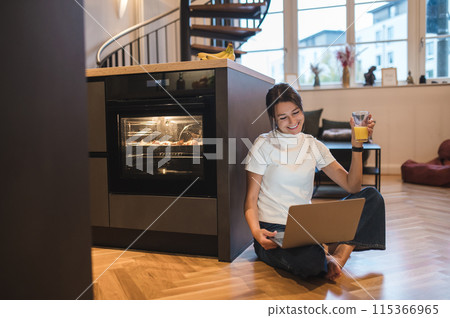 Young smiling woman having a video call and looking contented 115366965