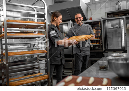 Professional bakers preparing fresh baguette in small bakery Professional bakers preparing fresh baguette in small bakery 115367013