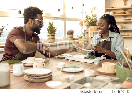 Two people looking involved while working with new pottery 115367038