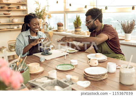 Two people looking involved while working with new pottery 115367039
