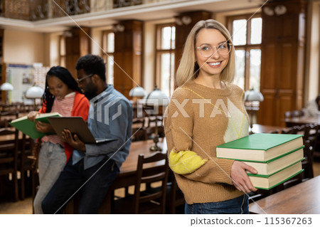 Group of young people in the library looking busy and involved 115367263