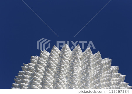 The top head part of big white Buddha statue in a blue sky background. The top head part of big white Buddha statue in a blue sky background. 115367384