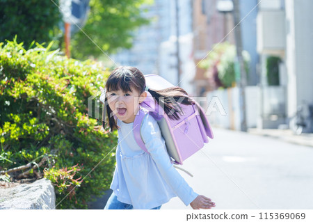Elementary school students running to school Elementary school students running to school 115369069