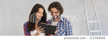 Smiling Couple Using Tablet for DIY Home Makeover Planning Banner 115369095