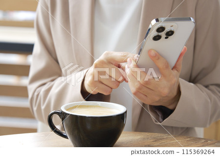 Businesswoman using smartphone in cafe, no face 115369264