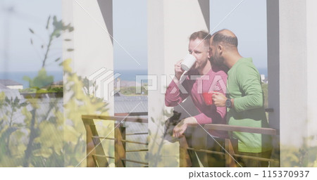 Image of plants over diverse male couple drinking coffee and embracing 115370937