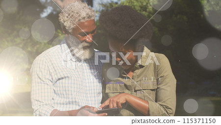 Image of light spots over african american couple using smartphone 115371150
