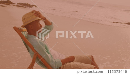 African american man sitting on the chair and relaxing at the beach 115373446