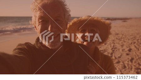 Happy caucasian senior couple talking a selfie together at the beach 115373462