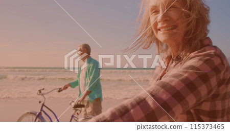 Happy caucasian senior couple riding bicycles together at the beach Happy caucasian senior couple riding bicycles together at the beach 115373465