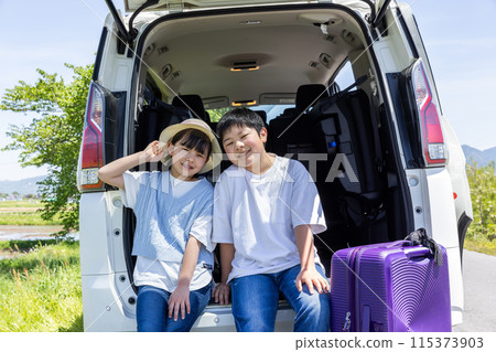 Child putting luggage in trunk Child putting luggage in trunk 115373903