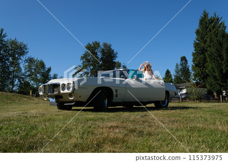 Young woman taking green suitcase from car trunk. Travel and vacations concept. Girl happy travel suitcases car summer landscape Young woman taking green suitcase from car trunk. Travel and vacations concept. Girl happy travel suitcases car summer landscape 115373975
