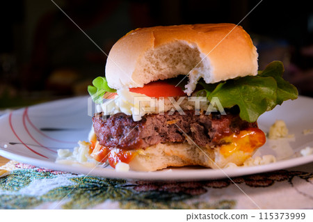 Take a bite home made beef burgers with lettuce and mayonnaise served on little wooden cutting board. Take a bite home made beef burgers with lettuce and mayonnaise served on little wooden cutting board. 115373999