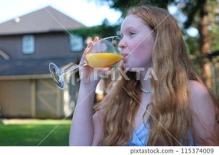 Girl drinks orange juice on the streets Passion fruit lemonade. Summer drink. Takeaway lemonade. Cold lemonade with ice in a female hand against a river view. Dancing with a drink in hand Girl drinks orange juice on the streets Passion fruit lemonade. Summer drink. Takeaway lemonade. Cold lemonade with ice in a female hand against a river view. Dancing with a drink in hand 115374009