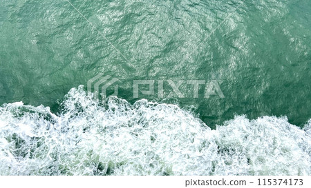 waves of the sea or ocean from under the ship floating quickly on the waves puffs of water with white foam the water itself Emerald Green very beautiful background for any travel text travel agency waves of the sea or ocean from under the ship floating quickly on the waves puffs of water with white foam the water itself Emerald Green very beautiful background for any travel text travel agency 115374173