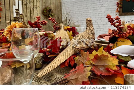 Wooden huge Table massive on which there are devices on wooden stands Mystical mysterious Halloween crows and other golden birds sit on the table Autumn bright orange and yellow flowers dry up 115374184