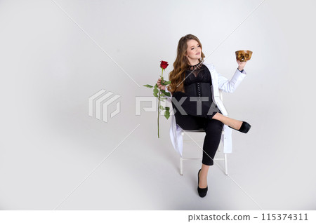 attractive holds a skull in her hands the concept suitable in the field of cosmology, medicine and healthcare Woman in a white robe and black evening dress on white background beautiful bright fierce 115374311
