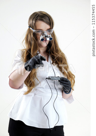 Illuminator with safety glasses and binoculars Dentist in binoculars ad stomatology microscopic procedures preparation and treatment of teeth tooth enamel cleaning teeth prosthetics filling canals Illuminator with safety glasses and binoculars Dentist in binoculars ad stomatology microscopic procedures preparation and treatment of teeth tooth enamel cleaning teeth prosthetics filling canals 115374455