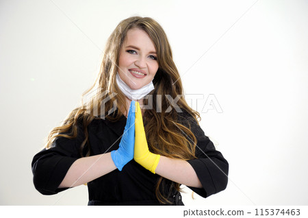 Let's pray for Ukraine female doctor folds two hands in latex gloves yellow and blue like flag of Ukraine stretches hands gives love calls for help salvation of Ukraine war terror Russia 115374463
