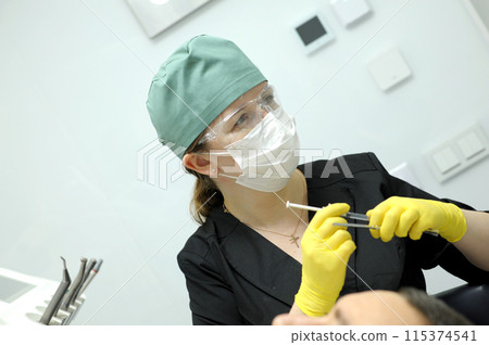 carpulse syringe Female doctor hands yellow gloves special instruments used in dentistry for local anesthesia simple design of a cylindrical body and piston syringe, disposable 115374541