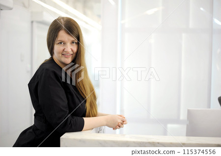long hair black clothes white computer laptop young woman sits at a computer at the reception of a white light office hospital dentistry any computer programmers 115374556