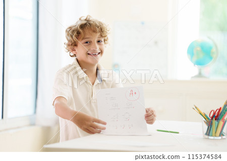 Child holding school test with excellent A grade. 115374584