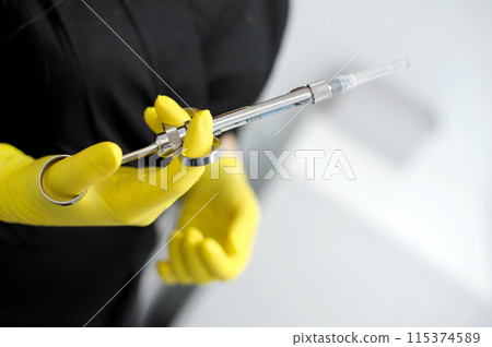 carpulse syringe Female doctor hands yellow gloves special instruments used in dentistry for local anesthesia simple design of a cylindrical body and piston syringe, disposable carpulse syringe Female doctor hands yellow gloves special instruments used in dentistry for local anesthesia simple design of a cylindrical body and piston syringe, disposable 115374589
