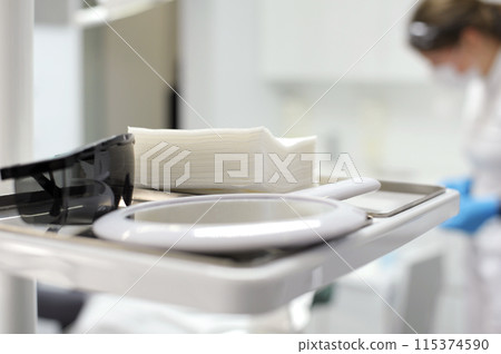 mirror napkins sunglasses on the background of the dental chair man blurred selective focus dental treatment stomatology 115374590