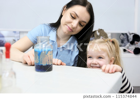 jar with blue bubbles Little scientist. Curious daughter play with mom engaged at education activity make funny experiment. Interested small girl watch elder sister doing chemical test use chemistry jar with blue bubbles Little scientist. Curious daughter play with mom engaged at education activity make funny experiment. Interested small girl watch elder sister doing chemical test use chemistry 115374844