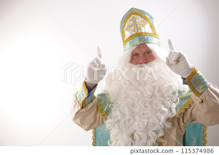 white rich beard and golden blue suit of St. Nicholas raised two fingers up listen to me look here attention Sinterklaas portrait positive emotions Dutch Santa Claus St Nicholas christmas new year white rich beard and golden blue suit of St. Nicholas raised two fingers up listen to me look here attention Sinterklaas portrait positive emotions Dutch Santa Claus St Nicholas christmas new year 115374986