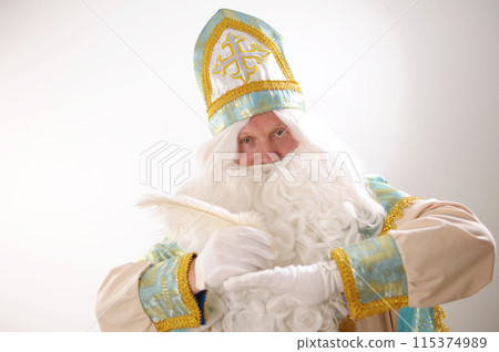 in the hands of St. Nicholas a white pen, he thinks what to write for the fulfillment of desires Sinterklaas portrait. USA on a white background. Dutch Santa Claus St Nicholas christmas new year 115374989