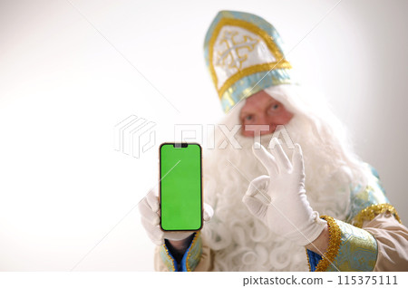Christmas pedestal phone chromakey still life with a Christmas card with Santa holding smartphone with blank screen and copy space Christmas, connection, technology, tradition and celebration concept Christmas pedestal phone chromakey still life with a Christmas card with Santa holding smartphone with blank screen and copy space Christmas, connection, technology, tradition and celebration concept 115375111