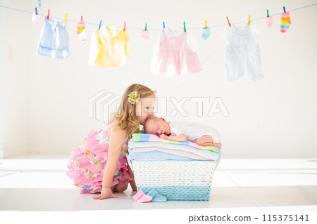 Baby boy on a pile of towels at laundry line 115375141