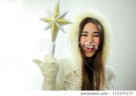 Goodbye New Year Hello Christmas girl in a white hood with fur and gloves laughs happily She put on her middle finger the star christmas tree fun laughter joy smile Winter cold comfort warm Goodbye New Year Hello Christmas girl in a white hood with fur and gloves laughs happily She put on her middle finger the star christmas tree fun laughter joy smile Winter cold comfort warm 115375177