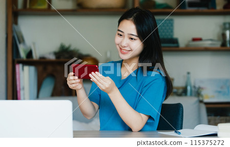一位年輕女子用智慧型手機學習 115375272