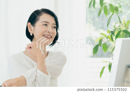 A woman stretching in front of a computer 115375502