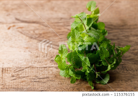Fresh organic mint on rustic wooden background. Selective focus. Fresh organic mint on rustic wooden background. Selective focus. 115376155