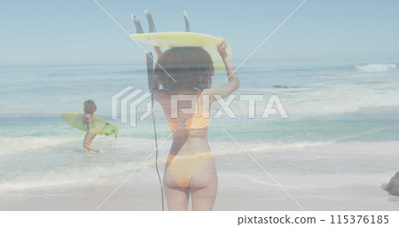 Image of biracial female surfer over female surfer at beach Image of biracial female surfer over female surfer at beach 115376185
