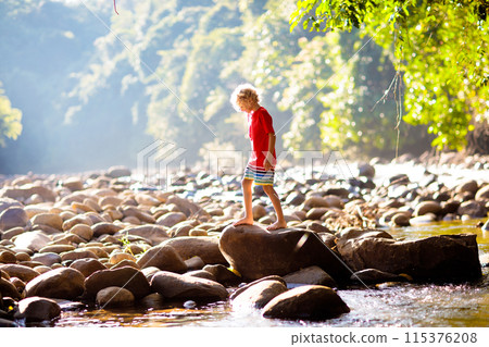 Child hiking in mountains. Kids at river shore. Child hiking in mountains. Kids at river shore. 115376208