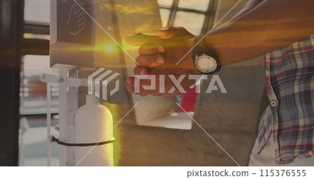 Image of landscape over african american man disinfecting hands 115376555