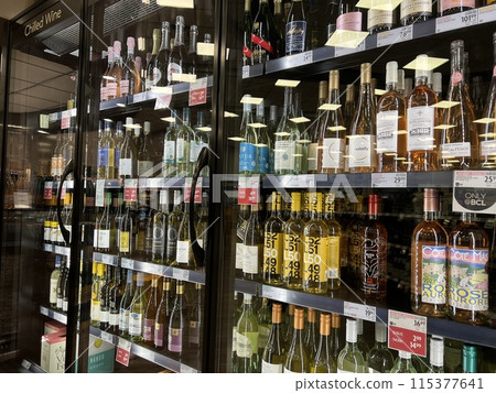 Display the sale of grape wine bottles in the fridge in the BC Liquor store. 115377641