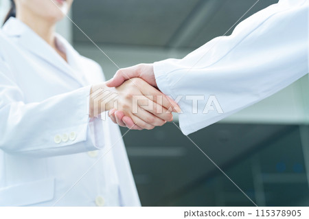 Doctors and researchers in white coats shaking hands 115378905